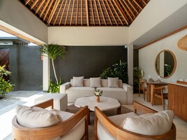 Una sala de estar moderna con techo de madera, un sofá, una mesa de centro y un comedor con sillas y una mesa.