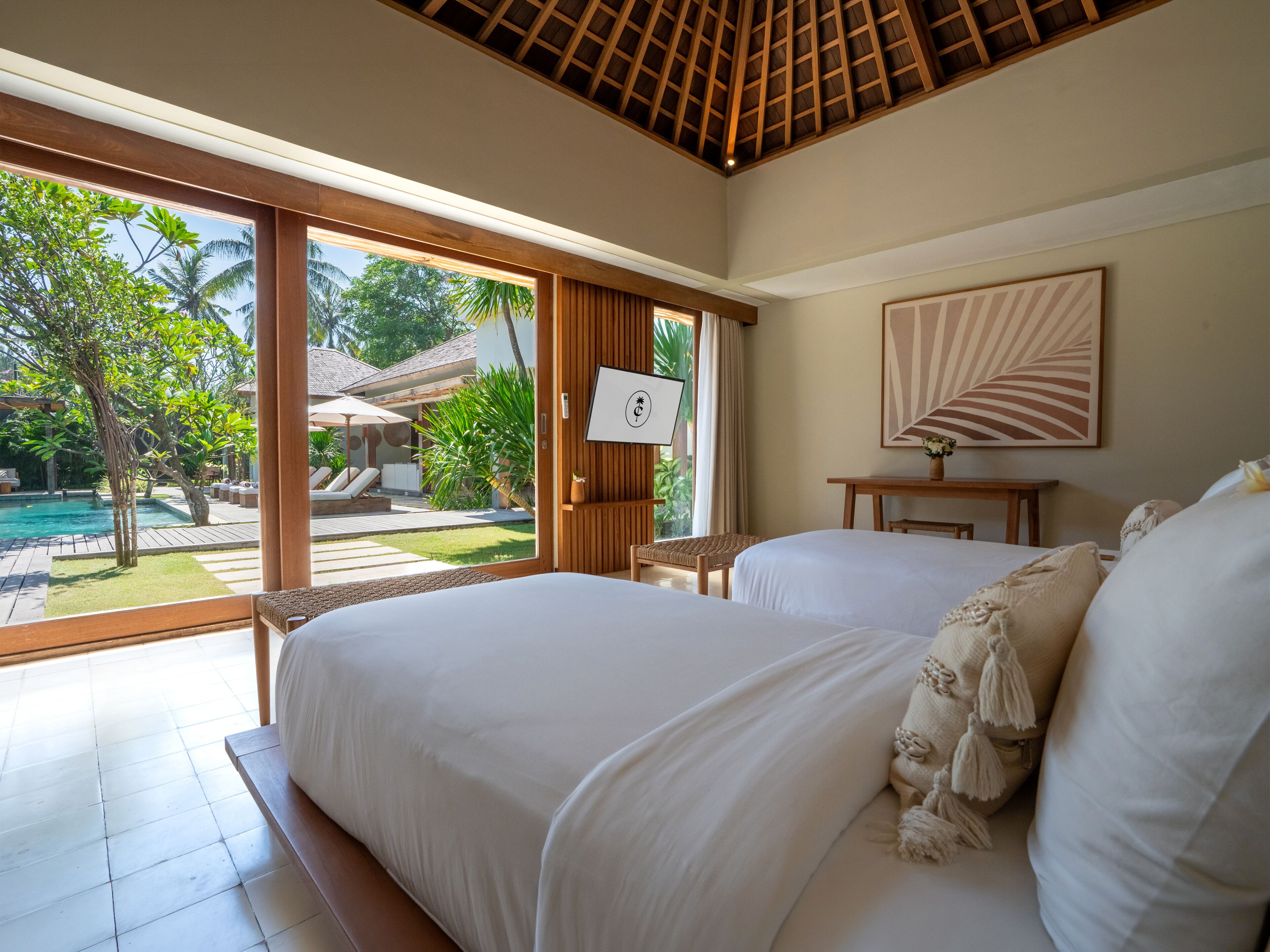 Une chambre d’hôtel avec deux lits, une grande fenêtre et une vue sur une piscine et un jardin.