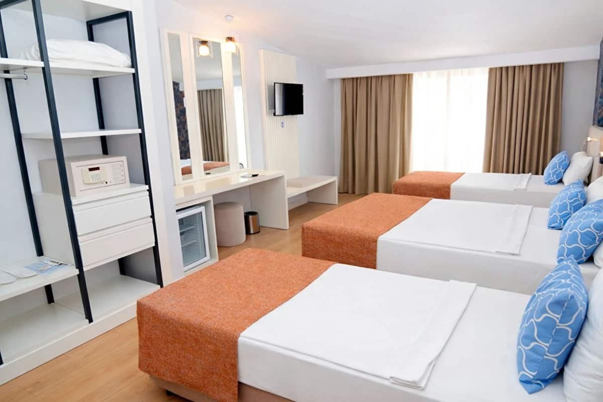 A hotel room with two beds, a desk, a TV, and a wardrobe.