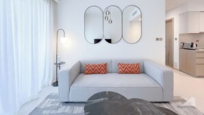 A modern living room with a grey sofa, two patterned throw pillows, a black floor lamp, and a large mirror above the sofa. - Incredible stay at Burj Royale Downtown (Dubai)