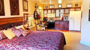 A bedroom with a large bed, a wooden headboard, and a nightstand with a lamp. - Cozy Victorian apartment, best view in Lake Las Vegas Resort and golf course. (Henderson)
