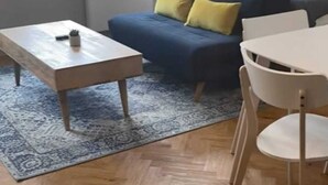 Un salon moderne avec un canapé, une table basse et un coin repas.