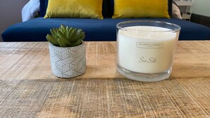 Une bougie sur laquelle est inscrit le mot « sel marin », posée sur une table en bois.