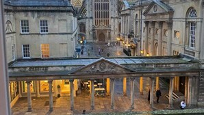 Un bâtiment historique doté d’une tour centrale et d’une cour intérieure couverte, ornée de colonnes.