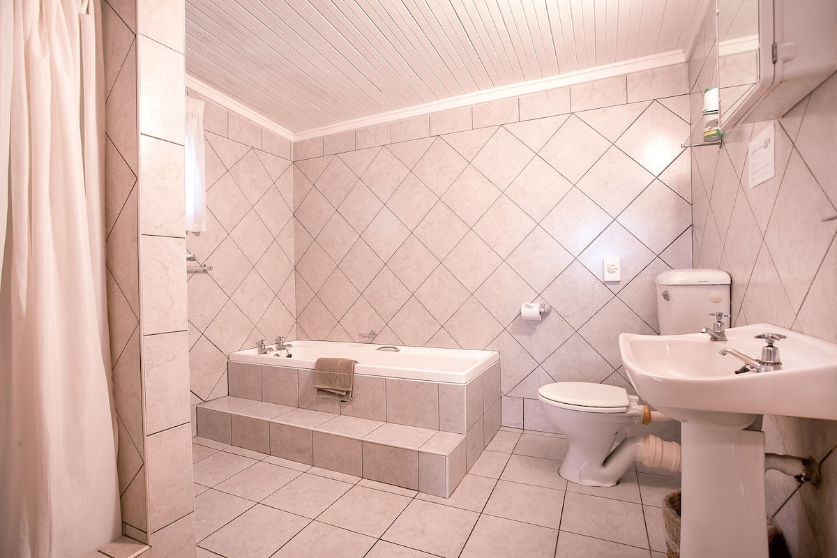 A modern bathroom with a bathtub, toilet, and sink.