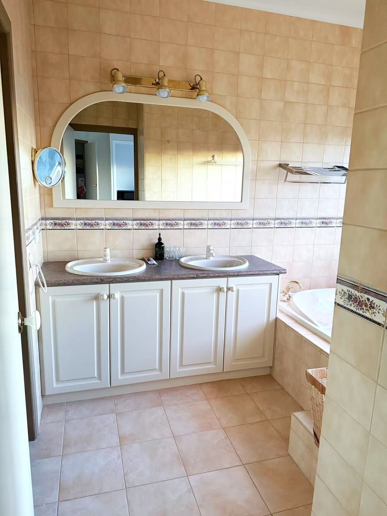 Un baño con dos lavamanos, un espejo grande y una bañera.