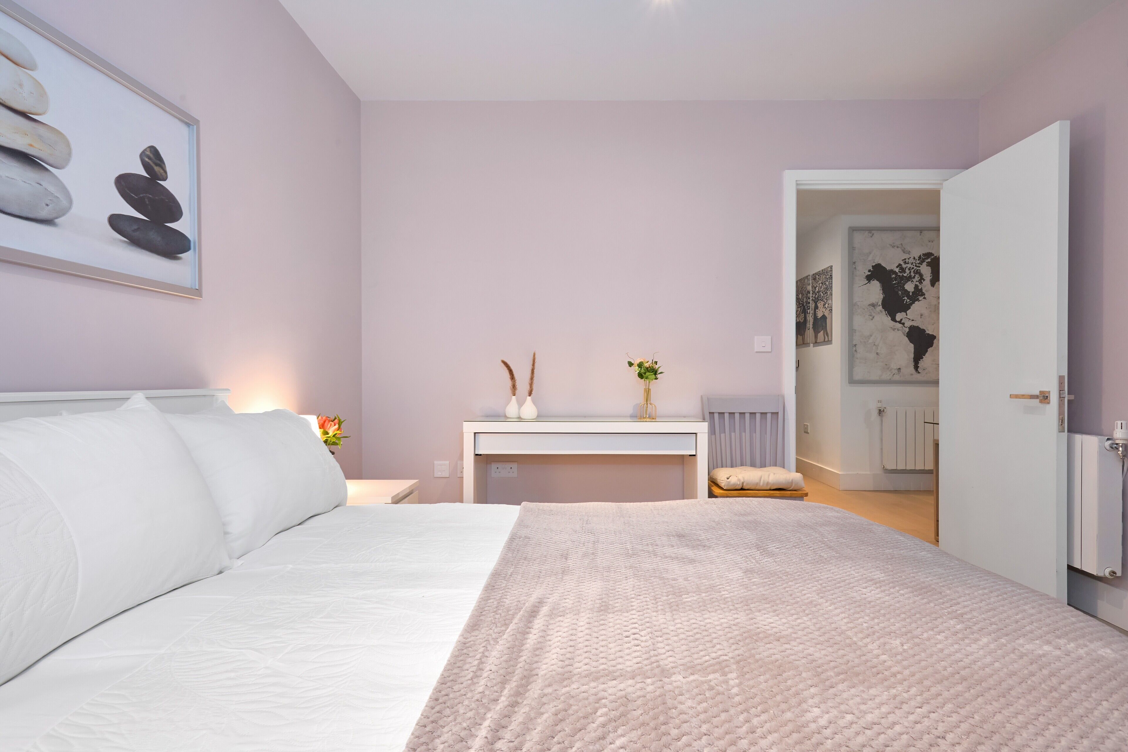 A bedroom with a bed, bedside table, and a desk.