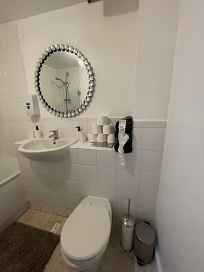 A bathroom with a sink, toilet, and a mirror with decorative beads. - Captivating 2-bed Apartment in London (London)