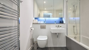 Een moderne badkamer met toilet, wastafel en douche.