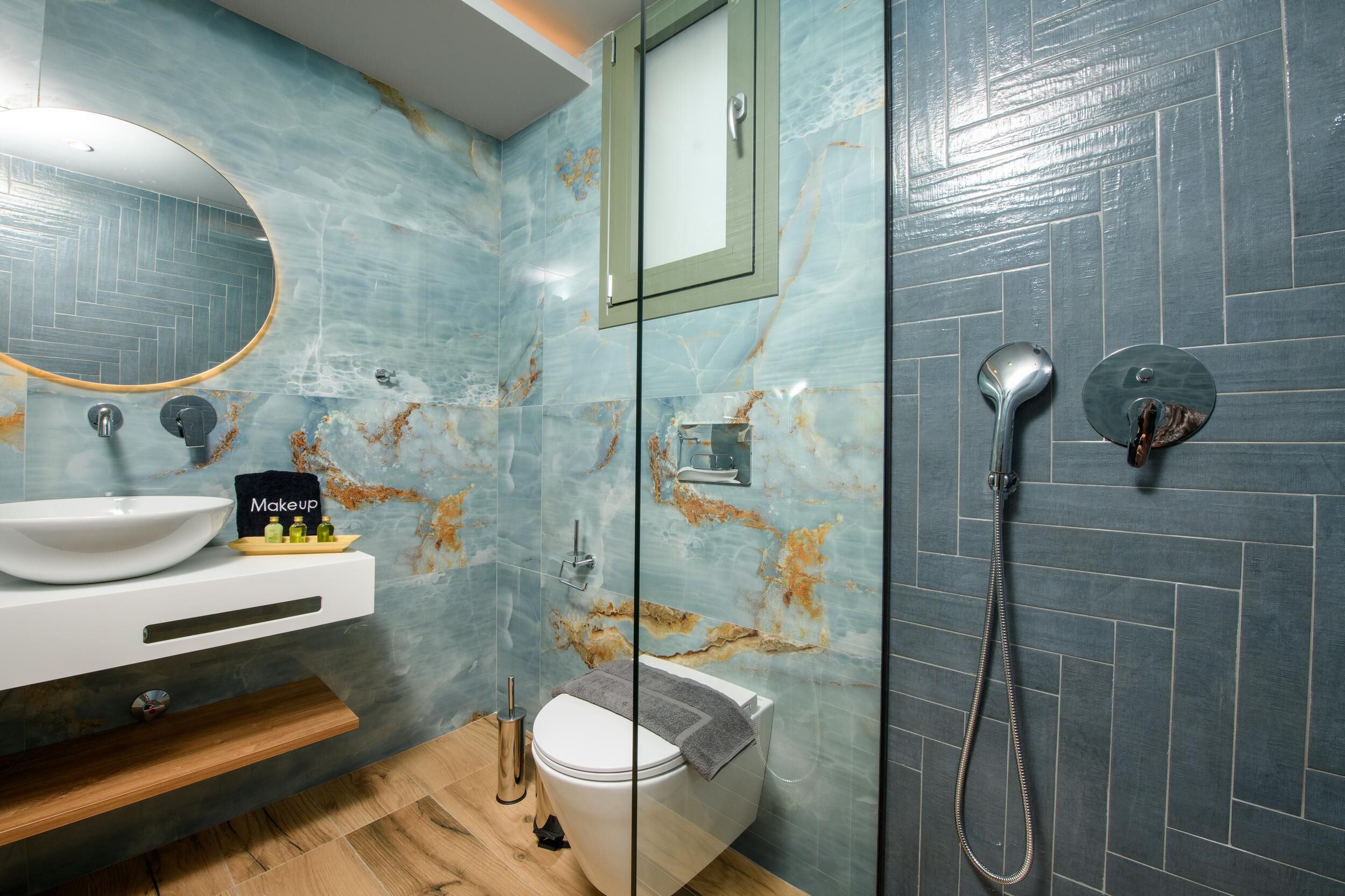 A bathroom with a white sink, a mirror, a toilet, and a shower.