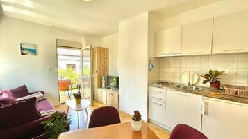 Comfort Apartment, Garden View | Living area | 32-inch LCD TV with cable channels