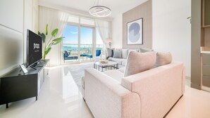 Una sala de estar moderna con un sofá grande, un televisor y una planta.