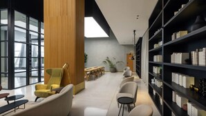 A modern library with bookshelves, seating, and a large window. - Modern Studio | Burj Khalifa View (Dubai)