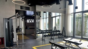 A gym with weightlifting equipment, a juice bar, and large windows. - Luxe 1BR w/ Stunning Sea Views and Infinity Pool (Dubai)