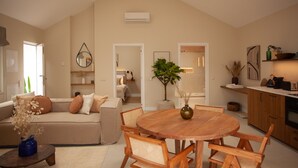 A spacious living area with a high ceiling, a wooden dining table, and a cozy sofa. - Vila Rodrigues (Lisbon)