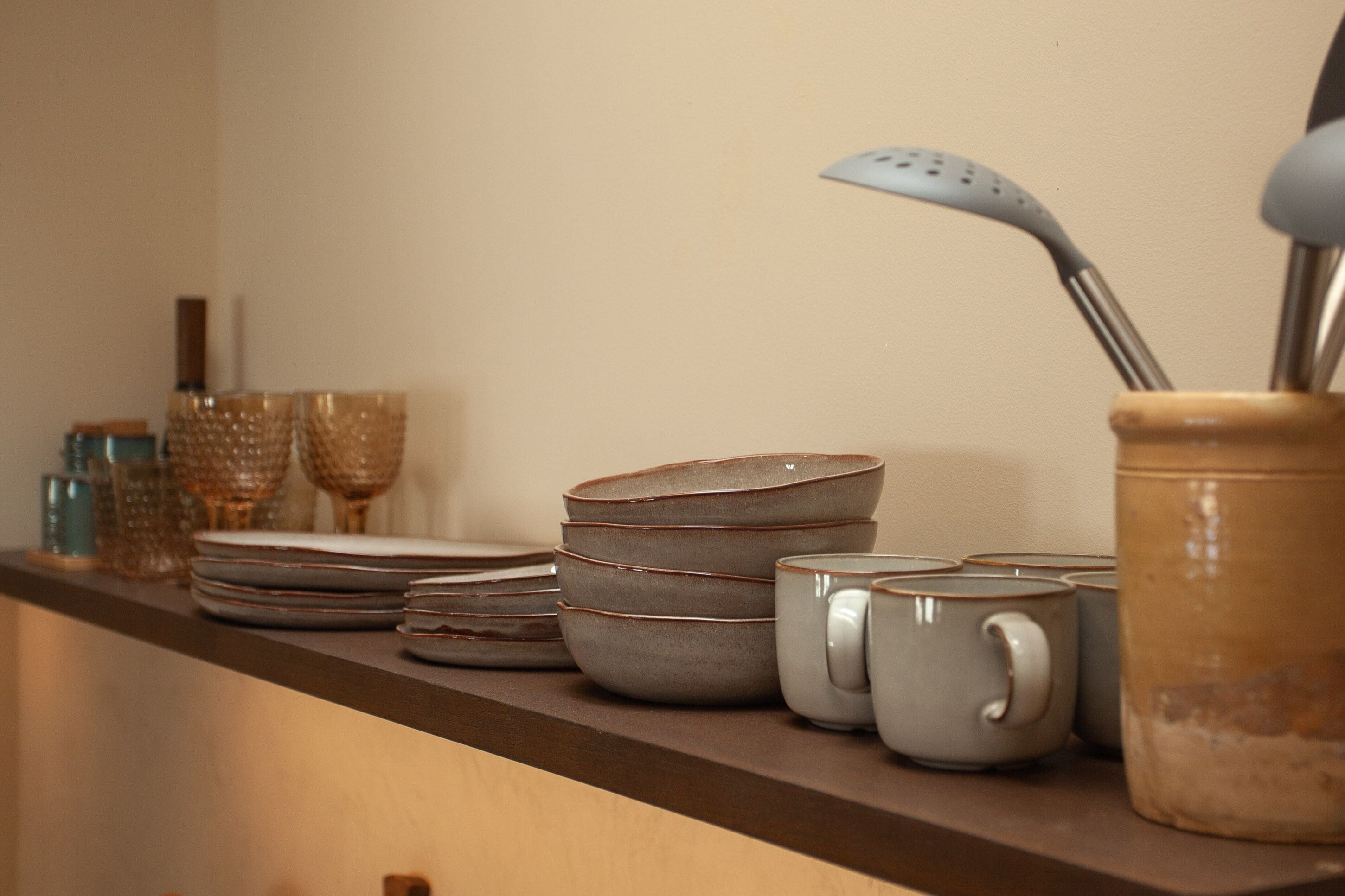 A kitchen counter with stacked plates, bowls, and mugs.