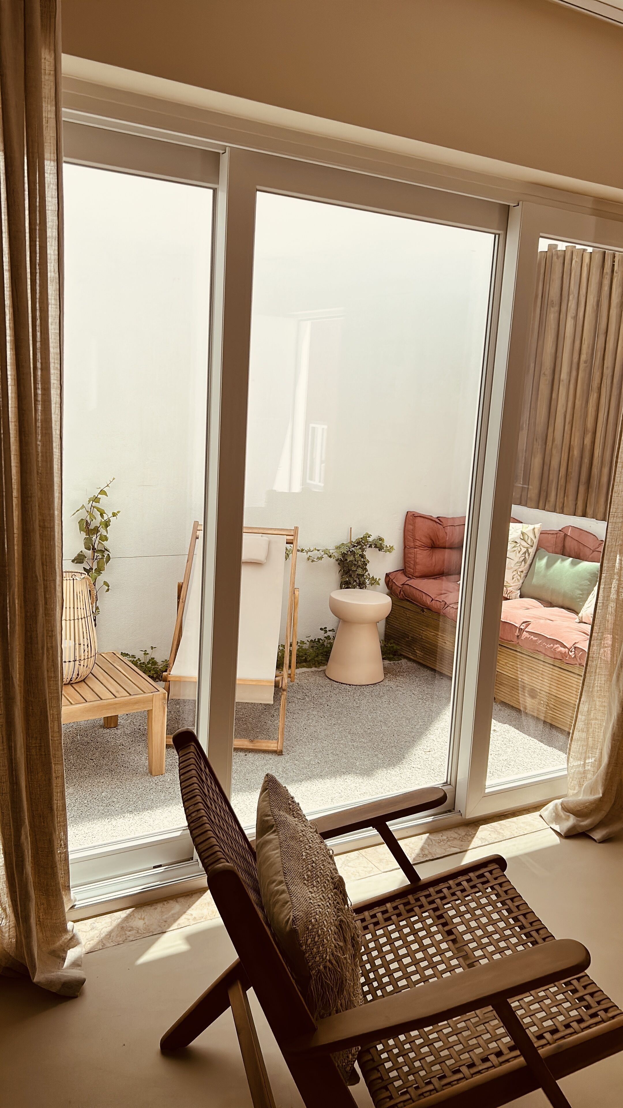 A modern living room with a large sliding glass door leading to an outdoor area.