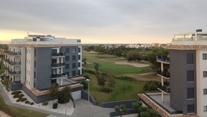A modern residential building with multiple floors, balconies, and a well-maintained lawn.