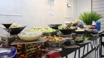 A buffet setup with various dishes and a decorative plant.