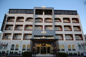 A multi-story hotel with a central entrance, balconies, and flags. - Kaya Hotel Amman (Amman)