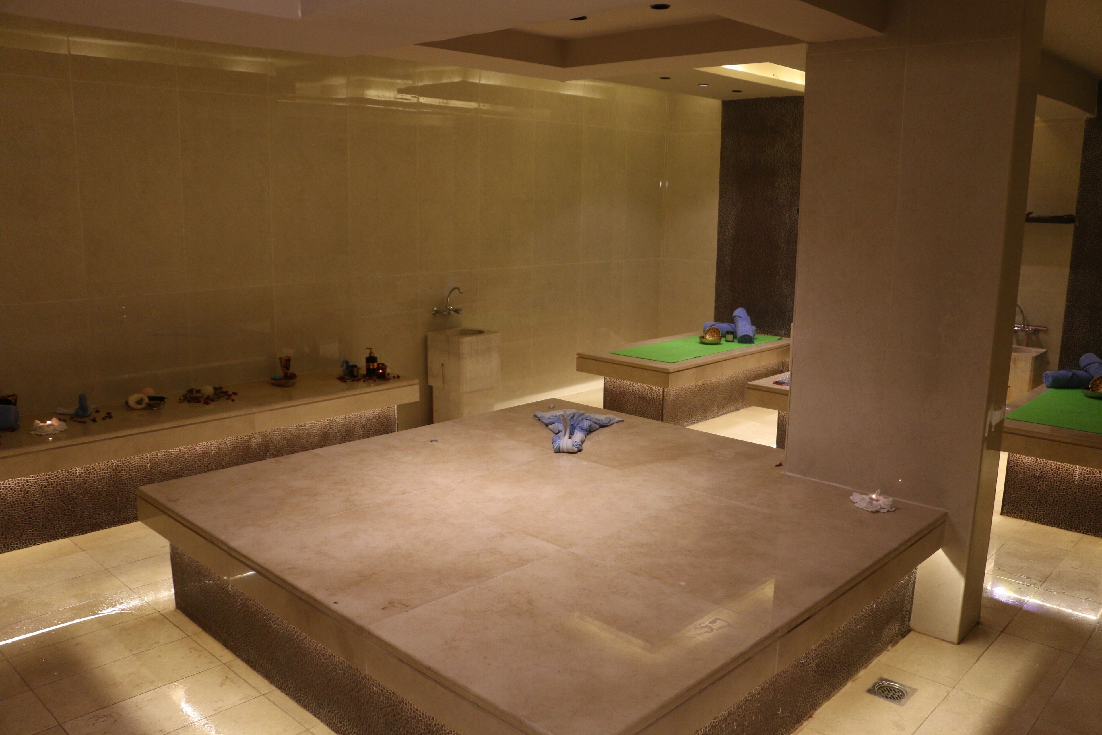 Un baño espacioso con una bañera grande, un lavamanos y una mesa de billar verde.