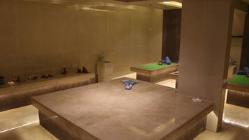 Un baño espacioso con una bañera grande, un lavamanos y una mesa de billar verde.