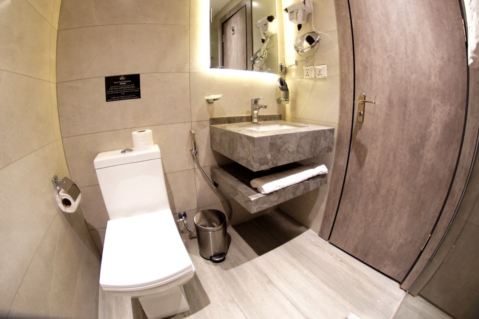 Een moderne badkamer met toilet, wastafel en douche.
