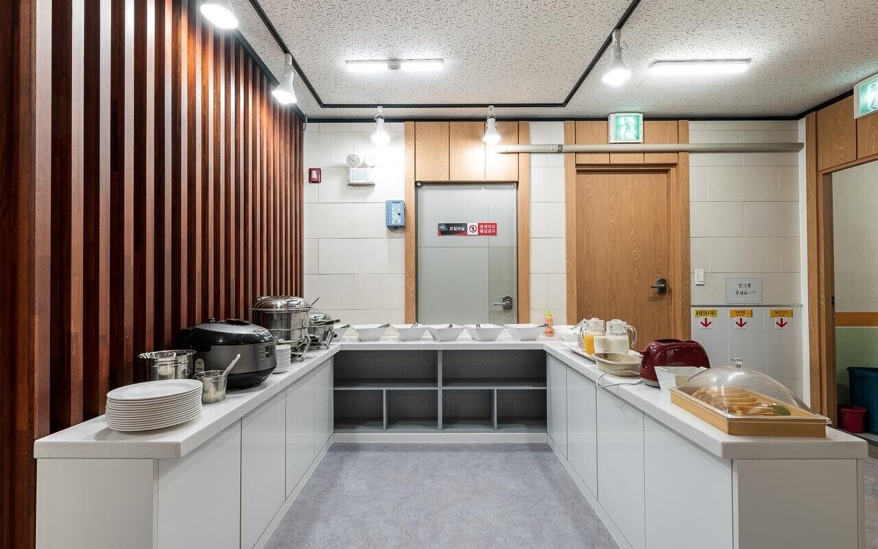 A modern kitchen area with a central island, white cabinets, and wooden accents.