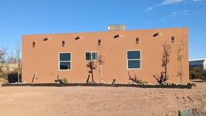Un bâtiment moderne doté d’un toit plat, de nombreuses fenêtres et surplombant un ciel d’un bleu limpide.