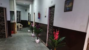 Un pasillo con plantas en macetas, un extintor y una puerta con un letrero.