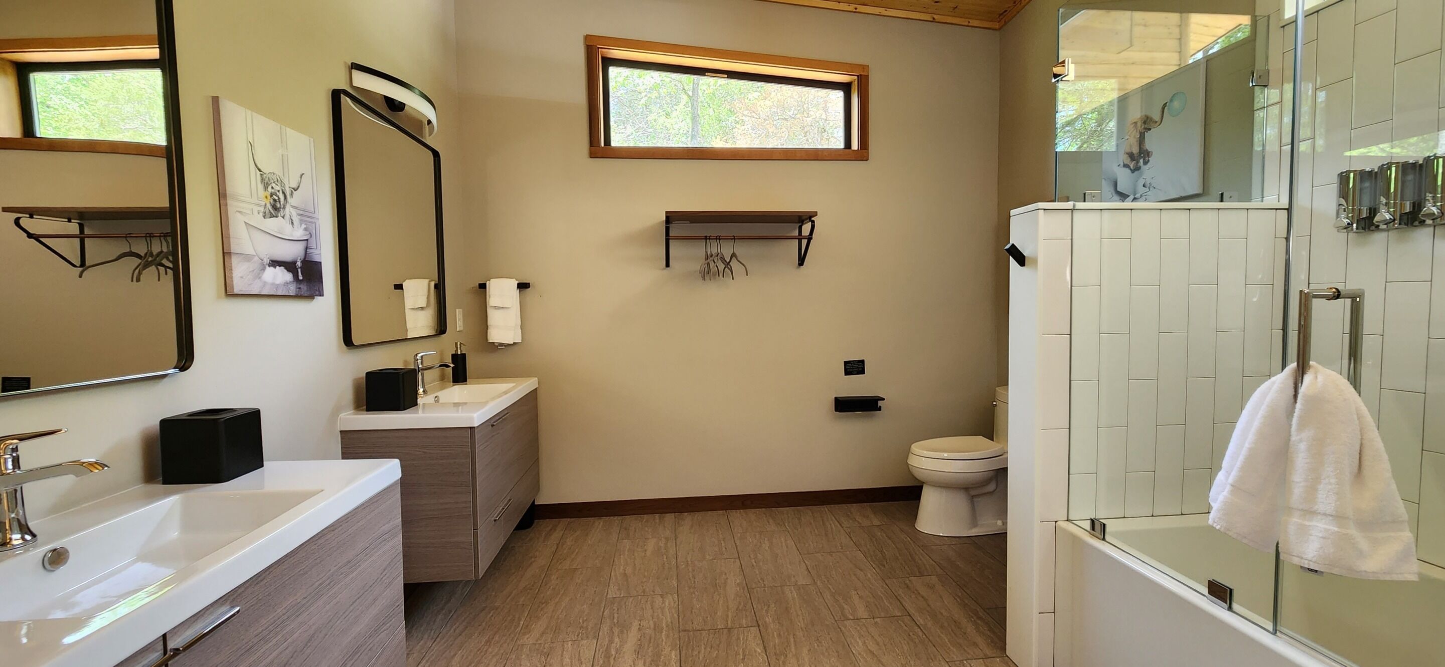 A modern bathroom with a large mirror, a sink, a toilet, and a shower area.
