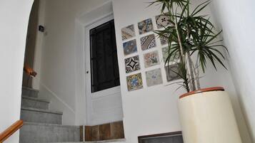 Un escalier avec une porte blanche et un mur décoré de différents carreaux.