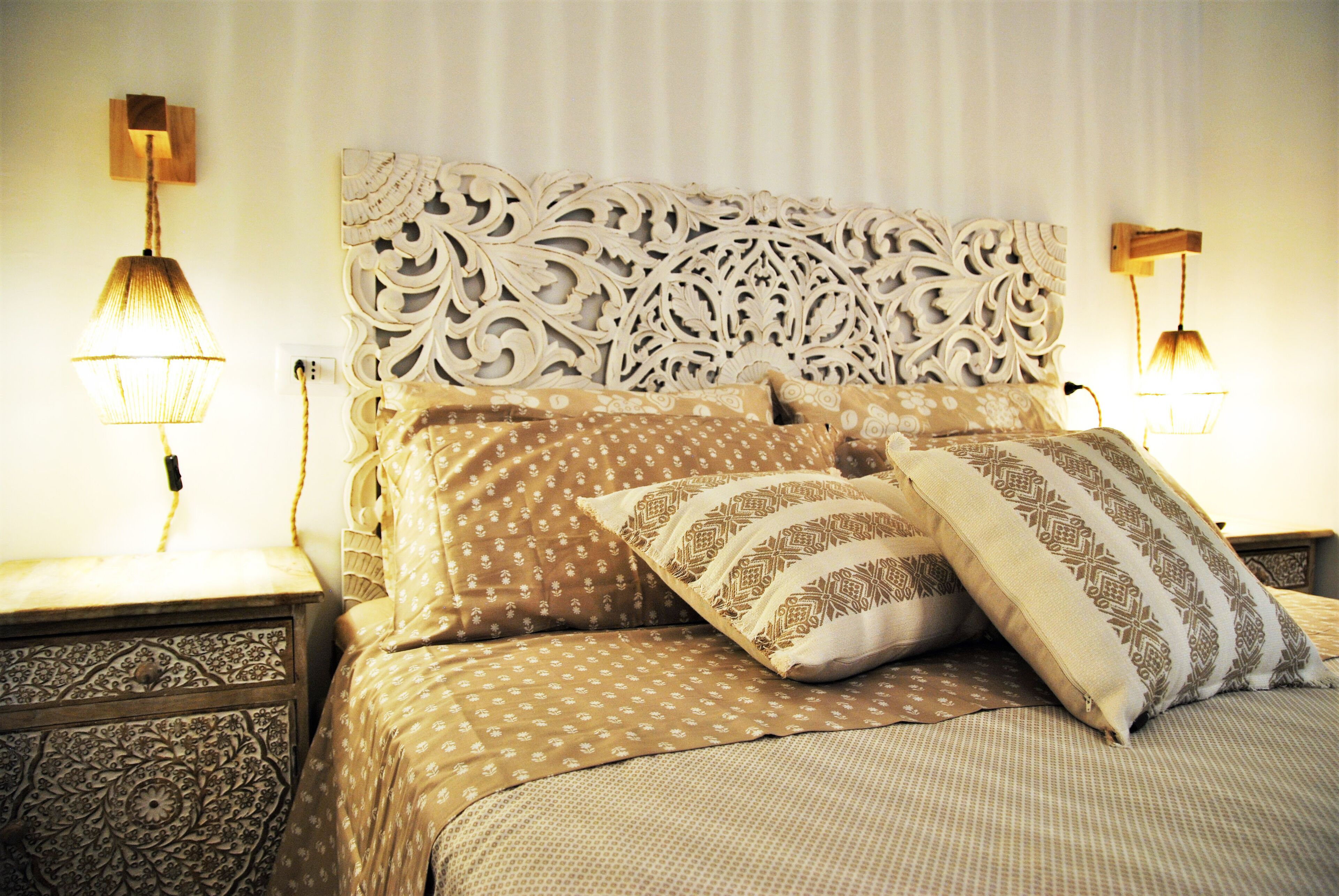 A bed with patterned bedding and a decorative headboard.