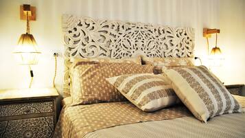 A bed with patterned bedding and a decorative headboard.