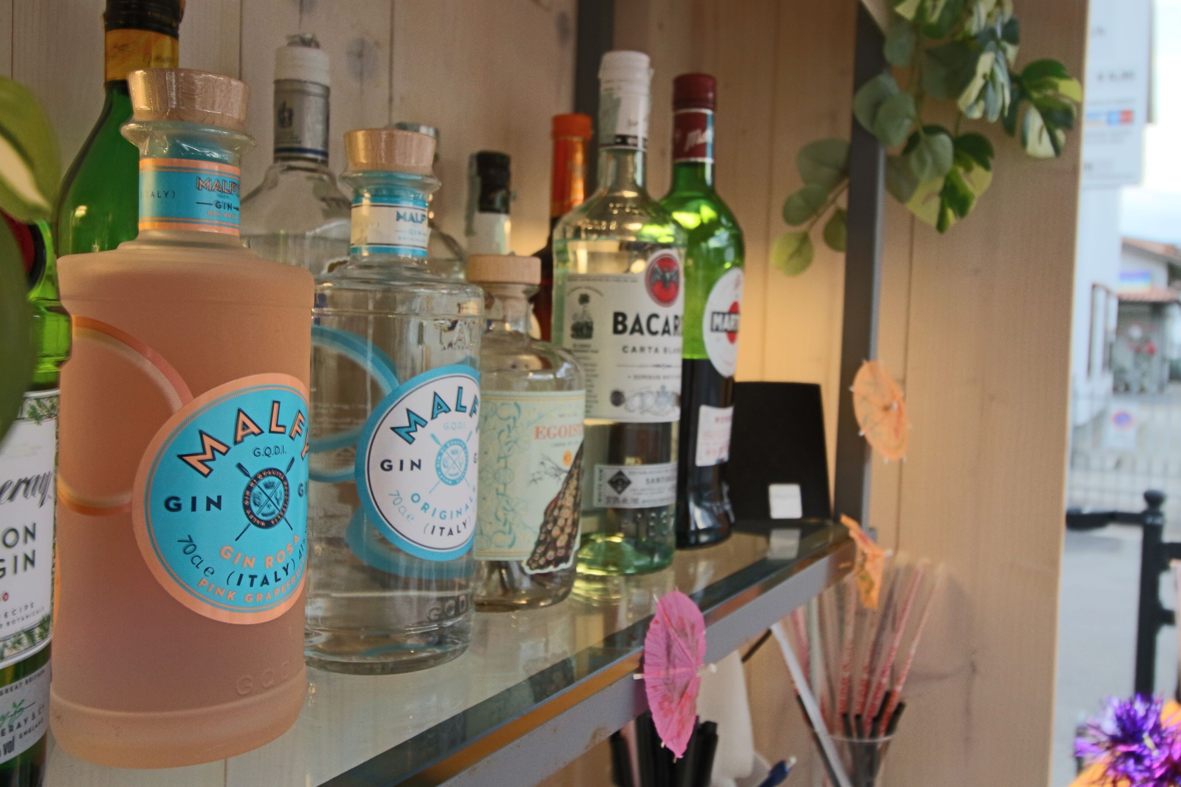 Una barra con diferentes botellas de ginebra y otras licores.