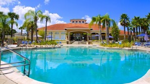 A swimming pool with a clear blue water, surrounded by palm trees and lounge chairs. - Sunnyside Villa 6 Bedroom Home by RedAwning (Kissimmee)