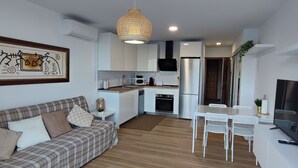 A modern apartment with a living room, kitchenette, dining area, and a TV. - Descanso Asegurado en Ambiente de Calma (CN)