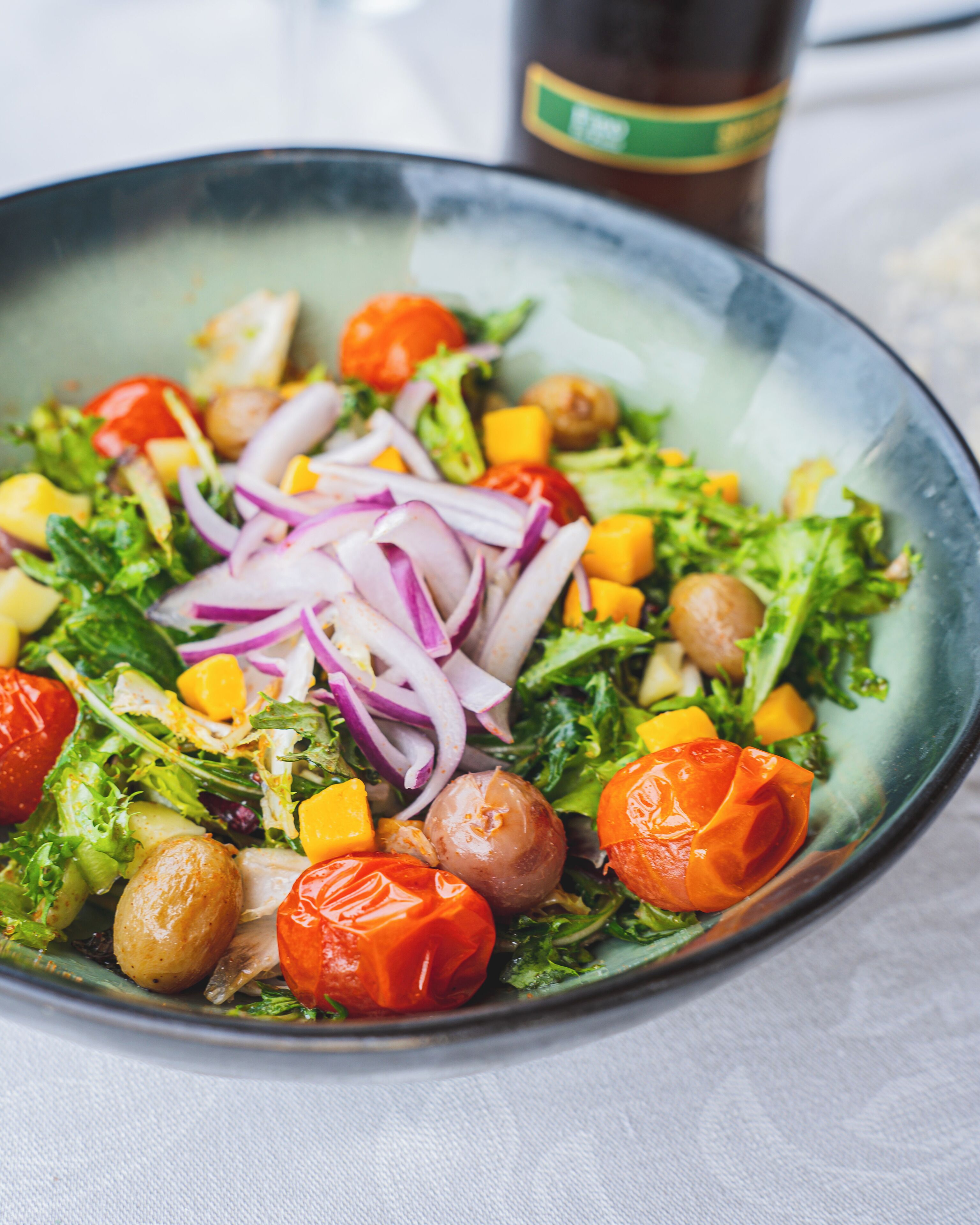 A bowl of salad with various vegetables and chickpeas.