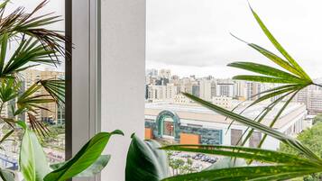 A view from a window overlooking a cityscape with tall buildings and a parking lot.