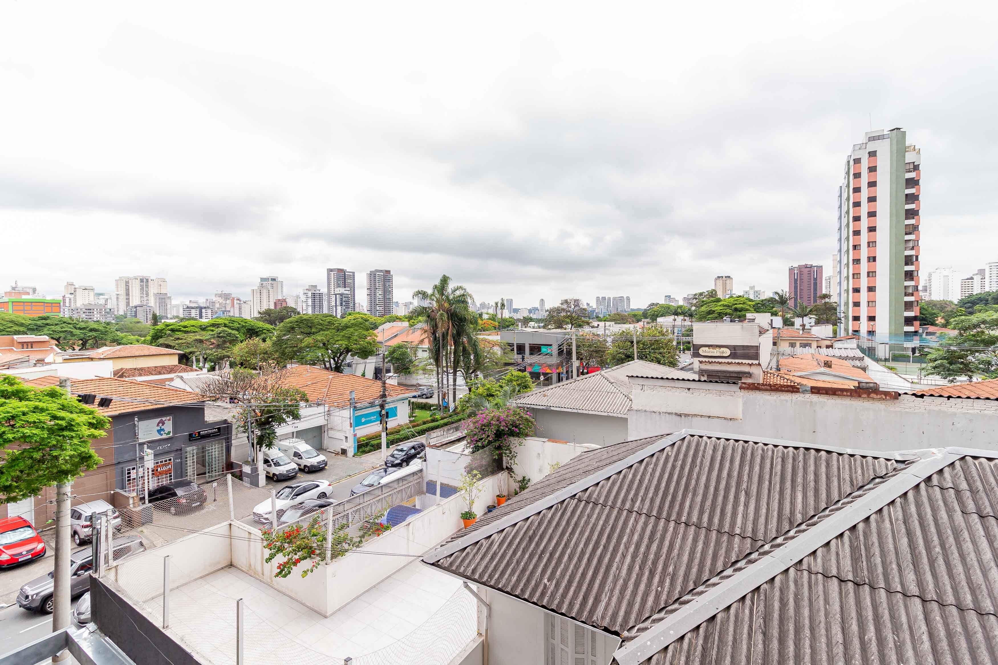 Un horizonte urbano con una mezcla de edificios residenciales y comerciales, incluyendo un edificio alto con fachada roja y blanca.