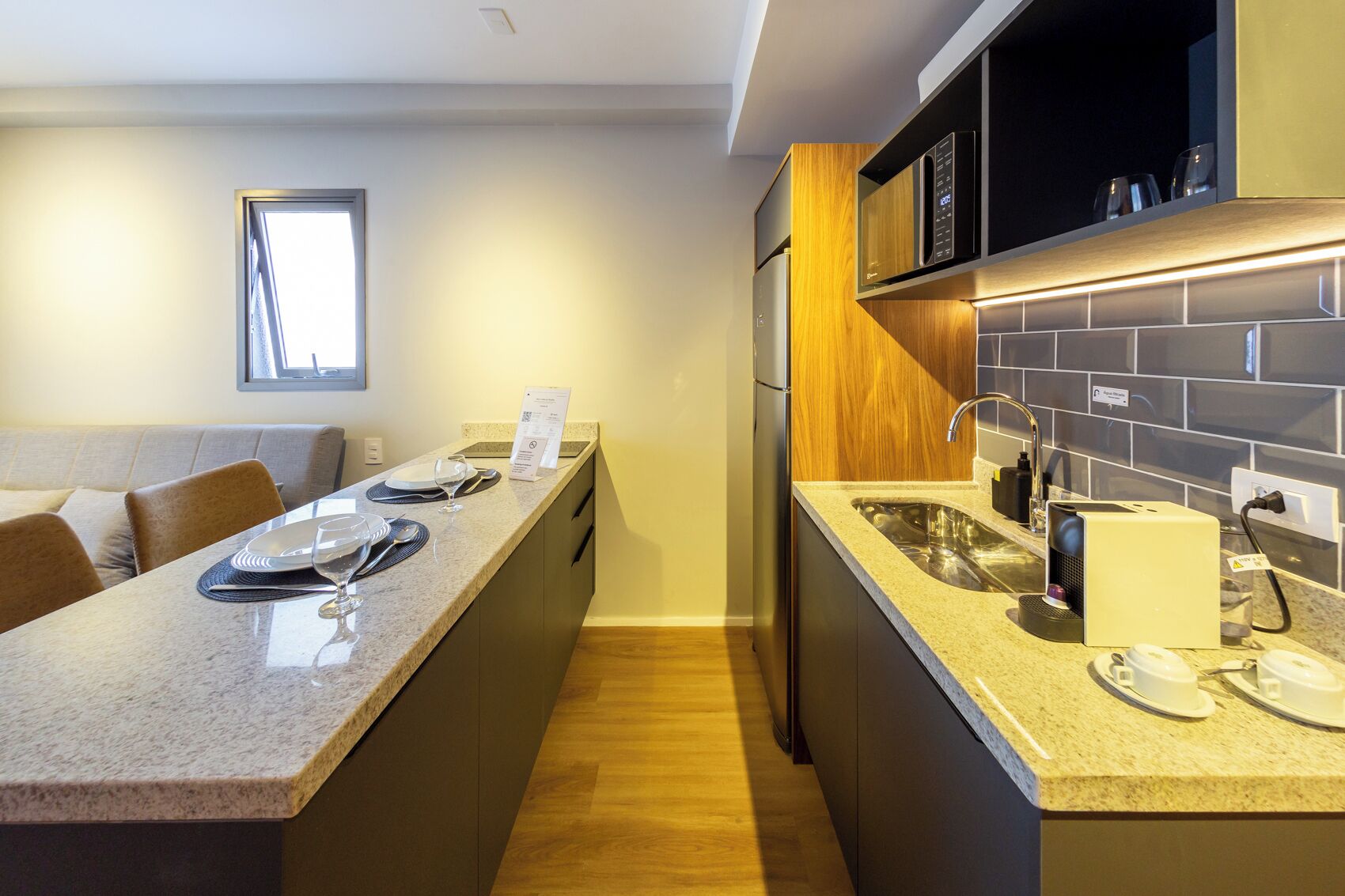 Una cocina moderna con encimera de granito, electrodomésticos de acero inoxidable y horno empotrado.