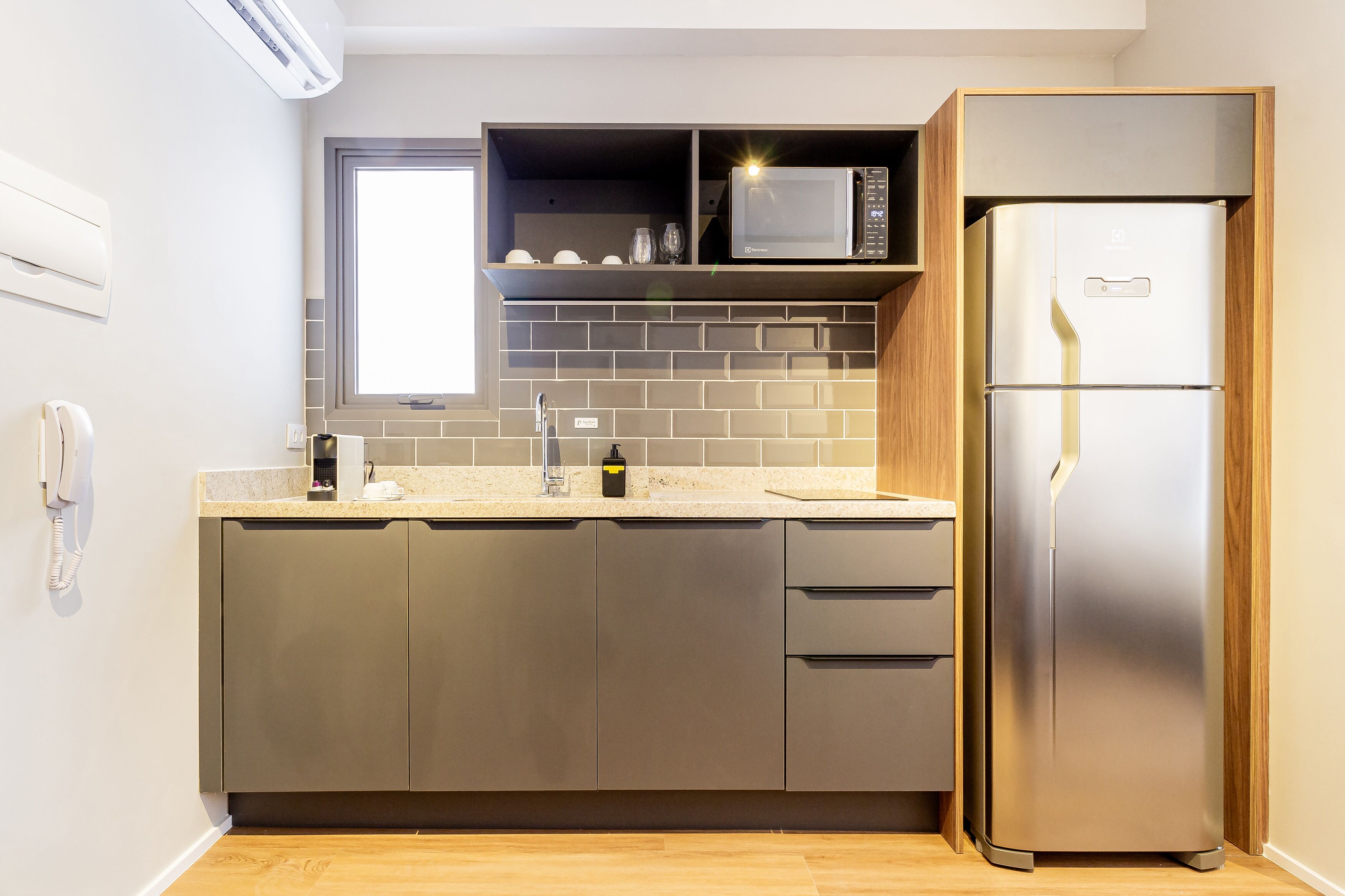 A modern kitchen with a stainless steel refrigerator, a microwave, and a built-in oven.