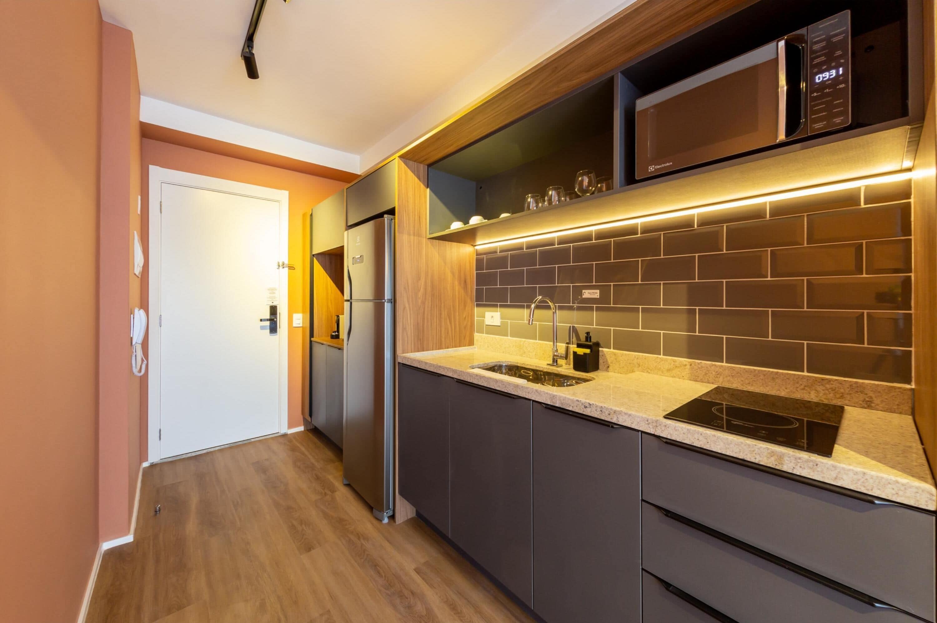 A modern kitchen with a built-in microwave, stainless steel appliances, and a granite countertop.