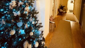 Een gang met een kerstboom versierd met versieringen en lichtjes.