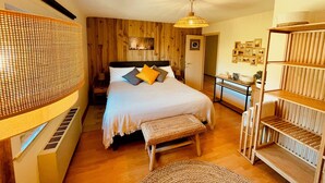 Een slaapkamer met een bed, nachtkastje en een houten plankunit.