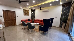 A modern living room with a red sofa set, two armchairs, and a coffee table.