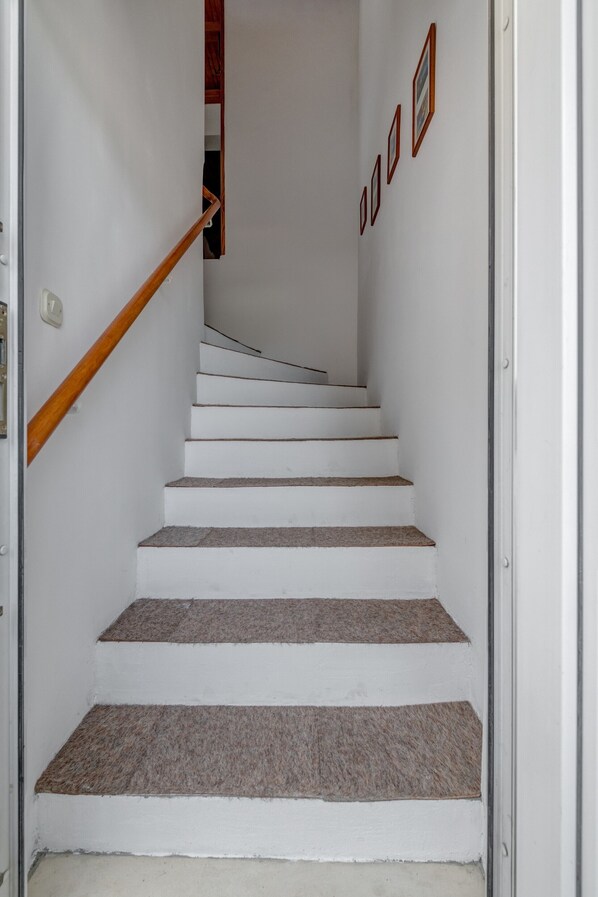 A staircase with white walls and a wooden handrail leading to a landing. - Spacious apartment Zvone with 3 balconies and parking (Split)