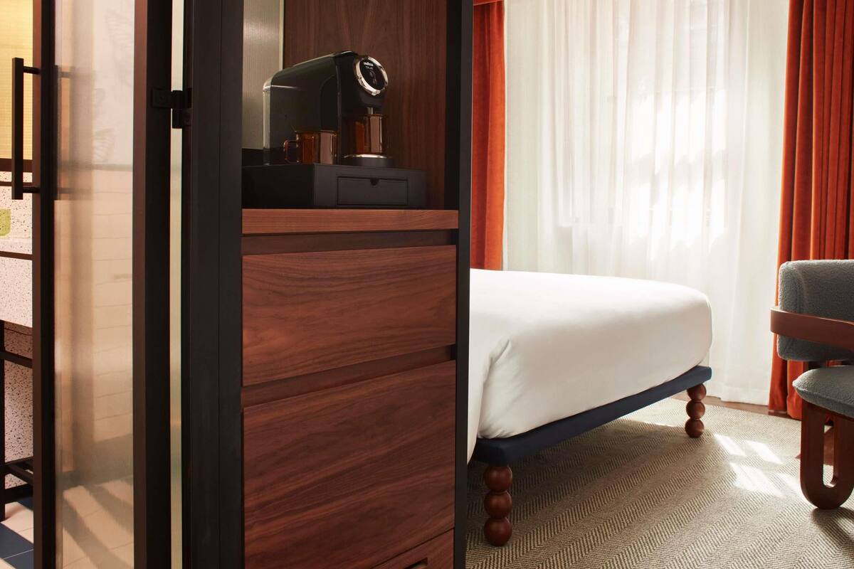 Une chambre d’hôtel équipée d’un lit, d’une chaise, d’un bureau et d’une machine à café.
