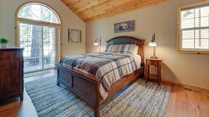 A bedroom with a wooden ceiling, a large bed with plaid bedding, a nightstand with a lamp, and a window with blinds. - 4 Mi to Downhill Ski Resort! Spacious Family Haven (Truckee)