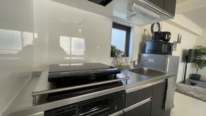 A modern kitchen with a built-in oven, microwave, and dishwasher. - Oak Stay Shimokitazawa  (Tokyo)